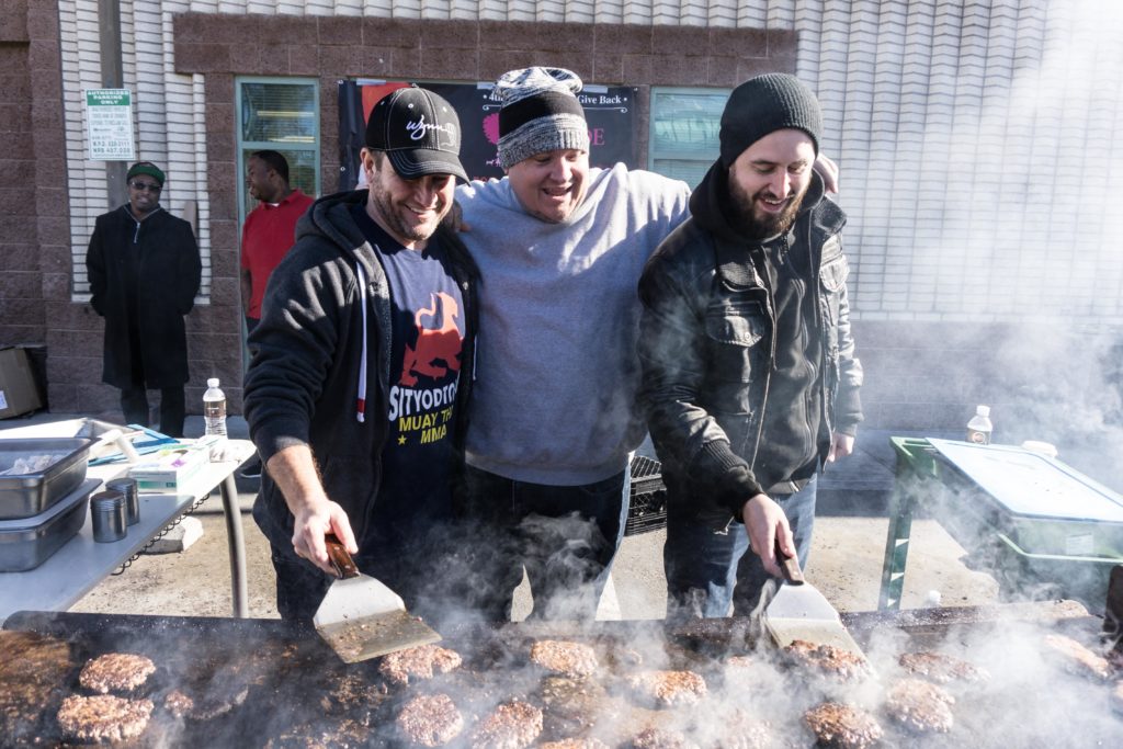 Darin Feinstein, Philip Limon, Dana Anderson flip burgers for the holiday charity event.