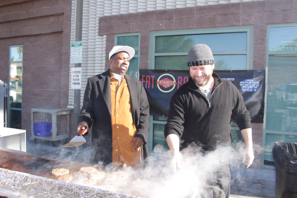 Eddie Griffin and Darin Feinstein flipping burgers at The Shade Tree holiday event