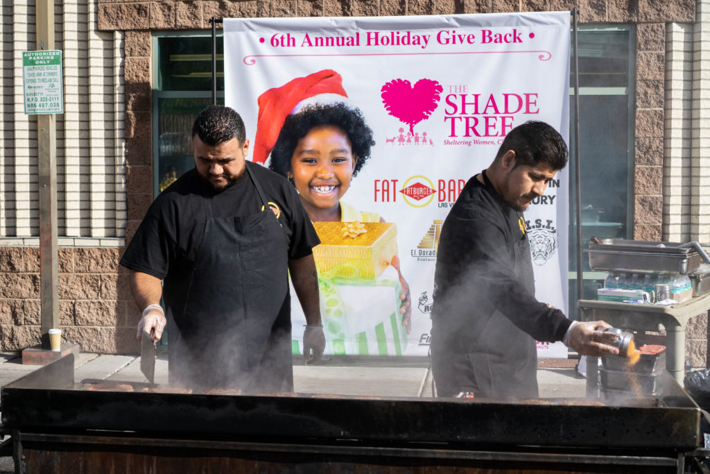 Fatburger employees grill burgers for The Shade Tree holiday event.